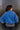 Back view of model wearing the Long Live Sweatshirt, which features washed blue fabric, a 3/4 snap-up neckline with a small collar, raglan balloon sleeves with ribbed cuffs, and a ribbed hemline