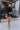 Full body front view of model wearing the What A Night Fringe Skirt, that features black satin fabric with silver beaded fringe, a wrap waist with a side tie, and a back zipper.