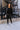 Full body front view of model wearing the Riley Waffle-Knit Top, which features black waffle knit fabric, raw hem details, scoop neckline, long sleeves with lettuce trim and drop shoulder.