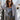 Front view of model wearing the All Or Nothing Cropped Blazer, that has brown and off white fabric with a plaid pattern, a cropped waist with a tortoise button closure, a collared neckline, and long sleeves.