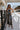 Full body front view of model wearing the Time Of My Life Pants, that  feature silver sheen fabric, two front pockets, a back zipper and a straight wide leg