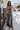 Full body front view of model wearing the Time Of My Life Pants, that  feature silver sheen fabric, two front pockets, a back zipper and a straight wide leg