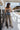 Full body back view of model wearing the Time Of My Life Pants, that  feature silver sheen fabric, two front pockets, a back zipper and a straight wide leg