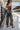 Full body back view of model wearing the Time Of My Life Pants, that  feature silver sheen fabric, two front pockets, a back zipper and a straight wide leg