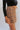 Close-up side view of model wearing the See You There Tweed Skort, which features a multi-colored tweed fabric, a shorts back, and a front skirt overlay. Worn with black bodysuit