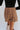 Close-up back view of model wearing the See You There Tweed Skort, which features a multi-colored tweed fabric, a shorts back, and a front skirt overlay. Worn with black bodysuit