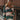 Front view of model wearing the Bristol Striped Sweater, which features green, cream, and pink stripes, a henley neckline, ribbed sleeves, and a ribbed hemline