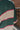 Close-up back view of model wearing the Bristol Striped Sweater, which features green, cream, and pink stripes, a henley neckline, ribbed sleeves, and a ribbed hemline