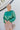Front view of model wearing the Lost In Your Eyes Top, which features a green satin fabric, long sleeves, a round high neckline with pleating, and an elastic waist.