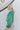 Side view of model wearing the Lost In Your Eyes Top, which features a green satin fabric, long sleeves, a round high neckline with pleating, and an elastic waist.