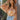 Front view of model wearing the Dream Girl Floral Bodysuit, that has camel and ivory floral print, a surplice neckline, flowy batwing sleeves, and a bikini bottom with a snap closure. Worn with jeans.