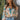 Front view of model wearing the First Love Floral Top, that has teal fabric with a metallic gold and ivory floral print, a surplice neckline, flowy balloon sleeves with smocked cuffs, and an elastic waist