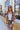 Front view of model wearing the Mocha Floral Cardigan, that has a light brown & dark brown, two-toned fabric, long sleeves, 3 button closures on the front, and cuffed sleeves. Worn unbuttoned over white tee.