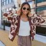 Front view of model wearing the Mocha Floral Cardigan, that has a light brown & dark brown, two-toned fabric, long sleeves, 3 button closures on the front, and cuffed sleeves. Worn unbuttoned over white tee.