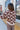 Back view of model wearing the Mocha Floral Cardigan, that has a light brown & dark brown, two-toned fabric, long sleeves, 3 button closures on the front, and cuffed sleeves. 