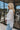 Side view of model wearing the For the Record Top, that features white fabric with a button-up front, a collared neckline, front chest pockets, and side slits.