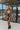 Full body front view of model wearing the Double Take Houndstooth Blazer, that has a black and mocha houndstooth pattern, tortoise buttons on each, front slit pockets, and long sleeves.