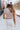 Close-up back view of model wearing the At Your Leisure Pants, which feature ribbed knit beige fabric and an elastic waist.