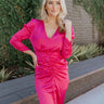 Front view of model wearing the New Look Midi Dress, that has pink satin fabric with a ruched midi-length skirt, a v-neckline, 3/4 length sleeves with ruching at the wrist, a back zipper and hook closure with a keyhole cutout