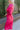 Side view of model wearing the New Look Midi Dress, that has pink satin fabric with a ruched midi-length skirt, a v-neckline, 3/4 length sleeves with ruching at the wrist, a back zipper and hook closure with a keyhole cutout