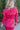Close-up back view of model wearing the New Look Midi Dress, that has pink satin fabric with a ruched midi-length skirt, a v-neckline, 3/4 length sleeves with ruching at the wrist, a back zipper and hook closure with a keyhole cutout