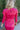 Close-up back view of model wearing the New Look Midi Dress, that has pink satin fabric with a ruched midi-length skirt, a v-neckline, 3/4 length sleeves with ruching at the wrist, a back zipper and hook closure with a keyhole cutout