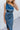 Close front view of model wearing the Athena Midi Dress, that has blue satin fabric, a one-shoulder neckline with a braided back strap, a back cutout, and an asymmetrical midi hem.