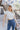 Front upper view of model wearing the Walk The Line Velvet Pants, which feature blue velvet with vertical and diagonal ribbed panels, flared legs, and a high-rise elastic waist.