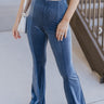 Front view of model wearing the Walk The Line Velvet Pants, which feature blue velvet with vertical and diagonal ribbed panels, flared legs, and a high-rise elastic waist.