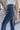 Close-up side view of model wearing the Walk The Line Velvet Pants, which feature blue velvet with vertical and diagonal ribbed panels, flared legs, and a high-rise elastic waist.