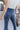 Close-up back view of model wearing the Walk The Line Velvet Pants, which feature blue velvet with vertical and diagonal ribbed panels, flared legs, and a high-rise elastic waist.