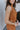 Side view of model wearing the Make It Count Tank Top, which features pleated fabric, a cropped waist, a sleeveless body, and a high neckline. Worn with matching skirt.