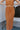 Close-up front view of model wearing the Make It Count Skirt, which features pleated fabric, an elastic waist, and a midi-length. Worn with matching top.