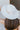 Back view of model's head; model is wearing the New Adventure Has, which is an ivory hat with a wide brim and a band with orange and grey embroidery.