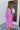 Side view of model wearing the Looking At You Romper, which features textured magenta fabric, a surplice neckline, a tie belt, and long bell sleeves.