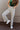 Front view of model wearing the v: Stella Raw-Hem Flare Jeans, which  feature light brown denim, flared legs with raw-hemlines, and front and back pockets.