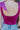 Close-up back view of model wearing the Luna Velvet Bodysuit in Pink, which features magenta velvet fabric, satin tie straps, and a cheeky bottom. Worn with jeans.