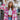 Front view of model wearing the Park City Plaid Shacket, which has a pink and white plaid pattern, a button-up front with tortoise buttons, front chest pockets and corduroy trim. Worn unbuttoned over white top