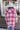 Back view of model wearing the Park City Plaid Shacket, which has a pink and white plaid pattern, a button-up front with tortoise buttons, front chest pockets and corduroy trim. 