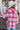 Back view of model wearing the Park City Plaid Shacket, which has a pink and white plaid pattern, a button-up front with tortoise buttons, front chest pockets and corduroy trim. 