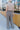 Full body back view of model wearing the New In Town Tweed Pants, which feature brown and black tweed fabric, a paperbag waist, a matching belt with a gold buckle, and wide legs.