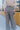 Back  view of model wearing the New In Town Tweed Pants, which feature brown and black tweed fabric, a paperbag waist, a matching belt with a gold buckle, and wide legs.