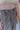 Close-up image of waistline; model is wearing the New In Town Tweed Pants, which feature brown and black tweed fabric, a paperbag waist, a matching belt with a gold buckle, and wide legs.