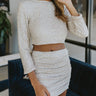 Front view of model wearing the Shine On Sequin Skirt in Champagne, that has beige mesh material with beige sequins, a beige lining, 3/4-length sleeves with shoulder pads, and an exposed back zipper.