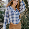 Front view of The Bonfire Escape Top features blue and white coloring fabric, checkered pattern, cropped waist, silver button up with a v neckline, and long sleeves with button cuffs