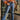 Front view of model wearing the Vervet: Let's Go Cropped Flares that have dark blue denim fabric, distressing, a frayed hem, a high-rise waist, mid flares, two front pockets, two back pockets, and a button and zipper closure