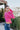 Side view of model wearing the Center Of Attention Sweater that has hot pink knit fabric, thick ribbed details, a round neckline, a front triangle hem, a straight hem in the back, and long sleeves
