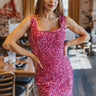 Front view of model wearing the VIP Sequin Dress that has fuchsia velvet and sequin fabric with a lining, a mini-length hem, a square neckline, a side zipper, and thick straps