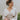 Frontal view of the Auburn Avenue Top that features an ivory colored material, a V neckline with a button closure, a long pleated sleeve, a smocked bottom with a ruffle hem, and a back tie closure.