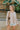 Frontal view of the To The Moon and Back Top that features a brown knit material, a quilted design, a V neckline, long sleeves, side slits, and a flowy fit.